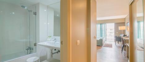 Une salle de bain moderne avec une douche en verre, un lavabo et un banc.