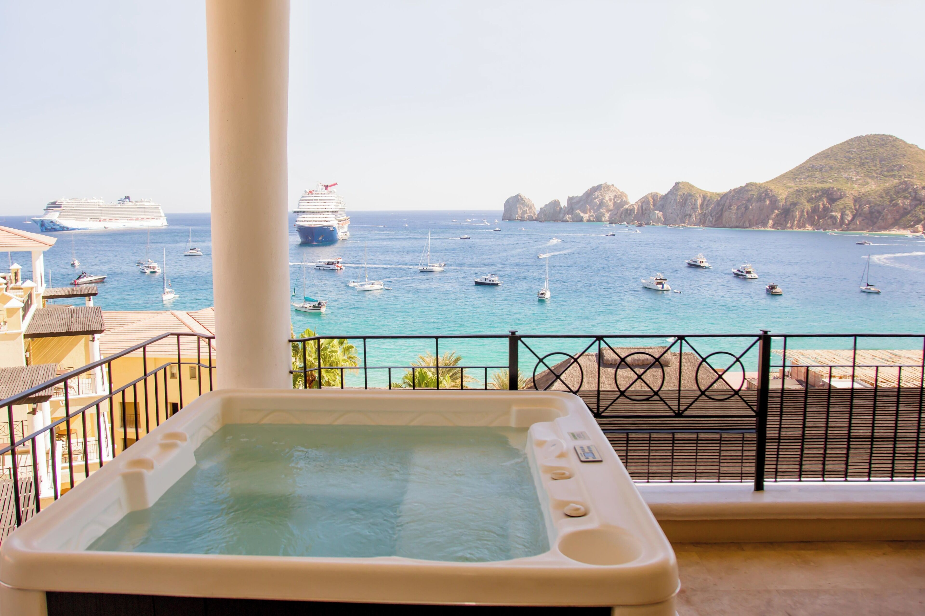 Uma banheira de hidromassagem com vista para o mar e barcos.