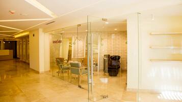A modern interior with a reception desk, a salon, and seating area.