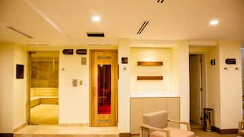 Een hotellobby met een receptiebalie, een zithoek met stoelen, een toilet en een prullenbak.