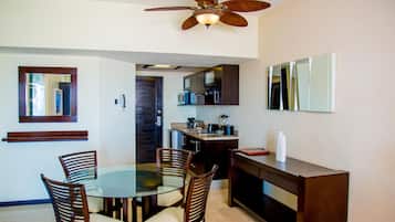 A compact kitchen with a dining area, a ceiling fan, and a microwave.