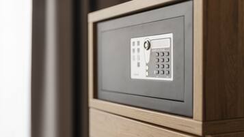 A close-up of a secure electronic keypad with a "SAFE 10E PLUS" label, part of a wooden-framed security panel.