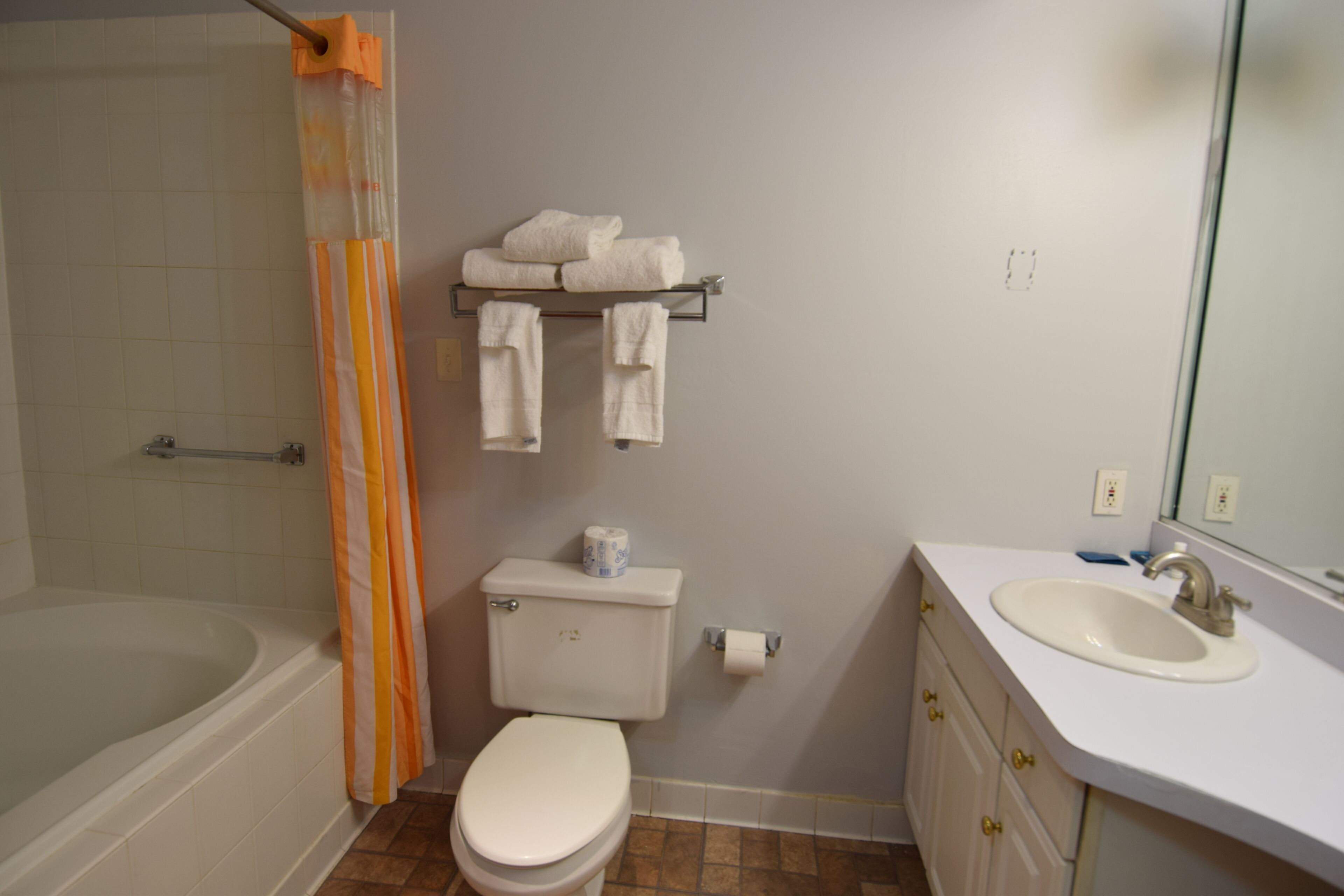 Ein Badezimmer mit Badewanne, Toilette, Waschbecken und Duschvorhang.