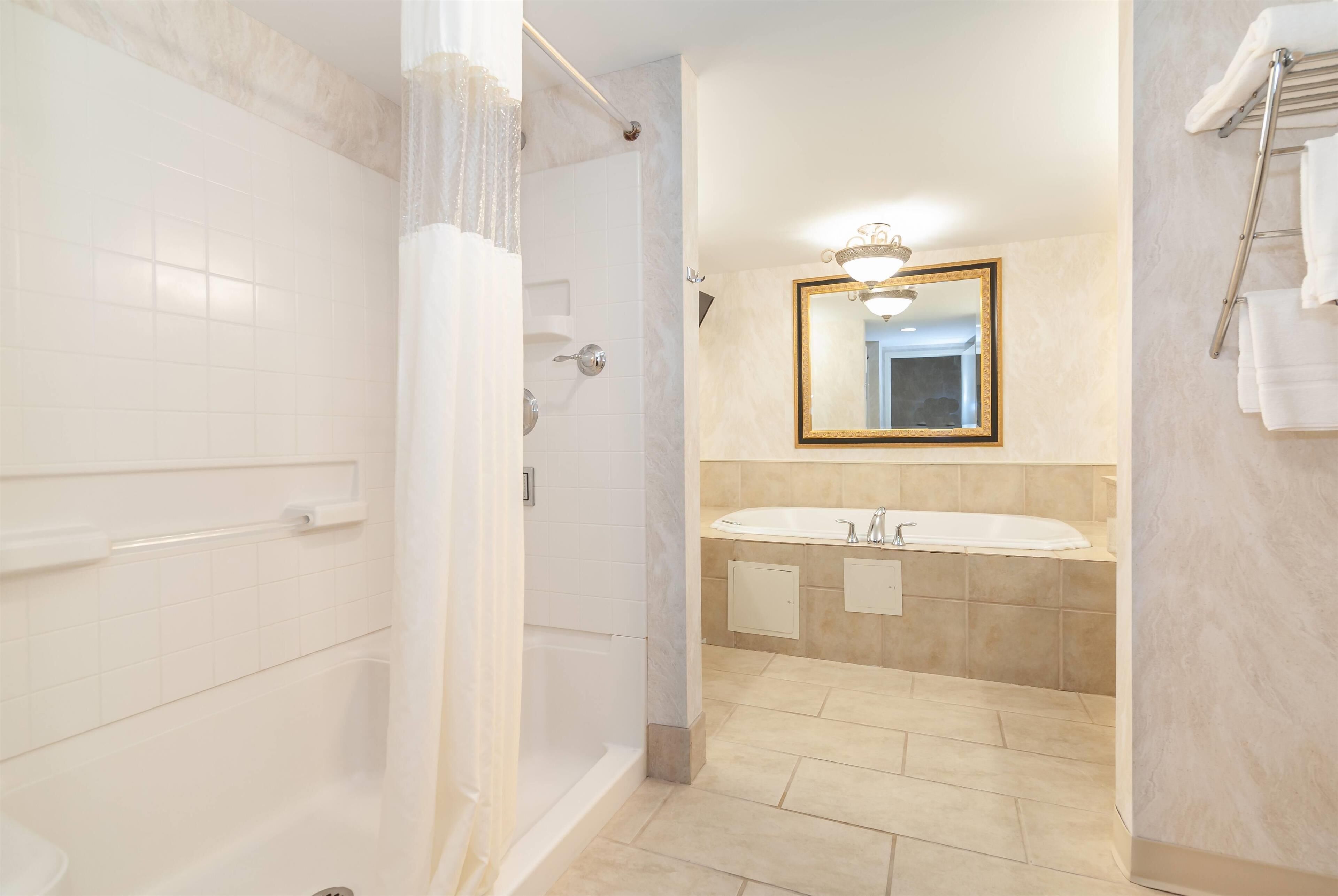 A modern bathroom with a walk-in shower, a large mirror, and a vanity with a sink.