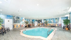 An indoor swimming pool with tiled flooring, benches, and a mural on the walls. - Bellissimo Hotel, Trademark by Wyndham Near Foxwoods Casino (North Stonington)