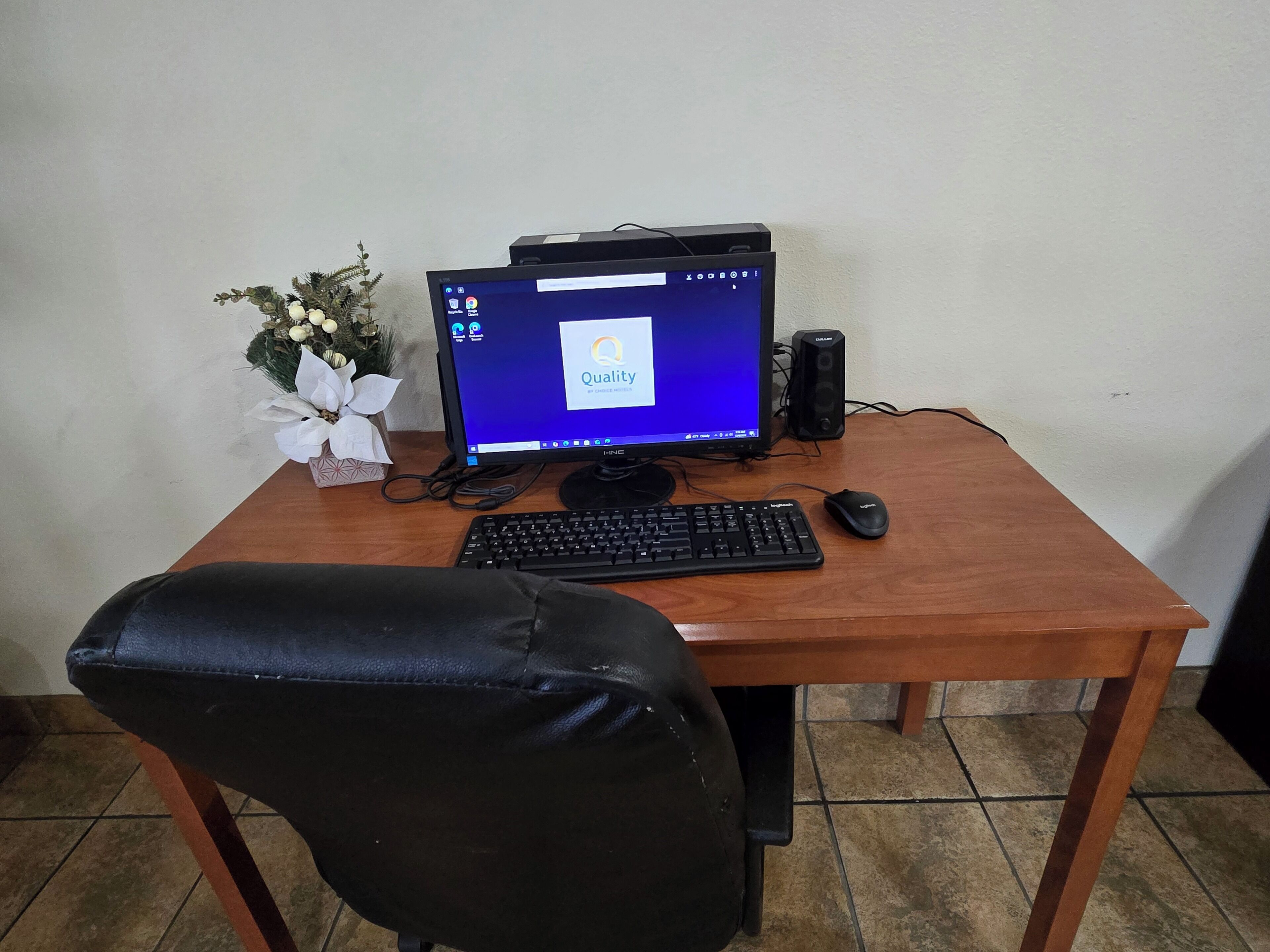 Een houten bureau met een computeropstelling, inclusief een monitor, toetsenbord en muis.