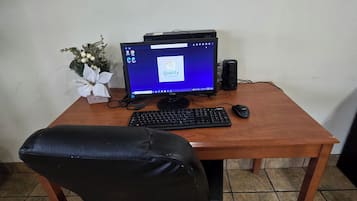 Een houten bureau met een computeropstelling, inclusief een monitor, toetsenbord en muis.