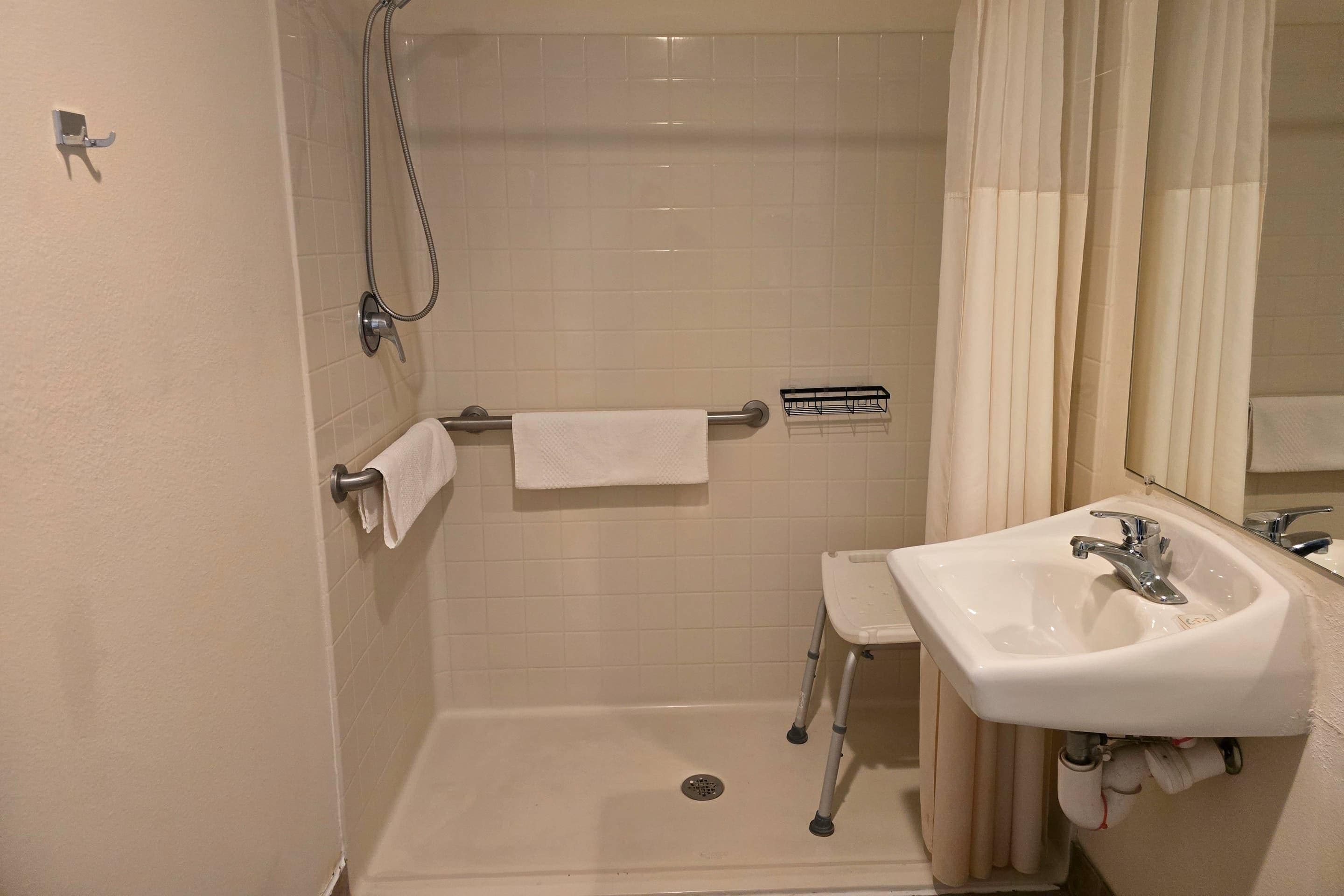 A bathroom with a shower, a sink, and a toilet.