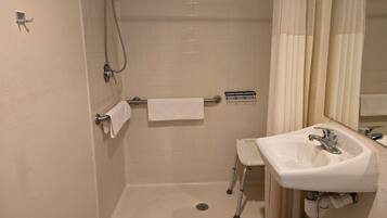 A bathroom with a shower, a sink, and a toilet.