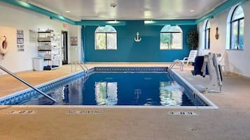 Une piscine intérieure avec un panneau indiquant qu’il est interdit de plonger, des panneaux d’avertissement concernant la présence d’un sauveteur et un panneau indiquant la capacité maximale de la piscine.