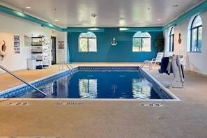An indoor swimming pool with a no diving sign, lifeguard warning signs, and a pool capacity sign. - Quality Inn Durand I-69 (Durand)