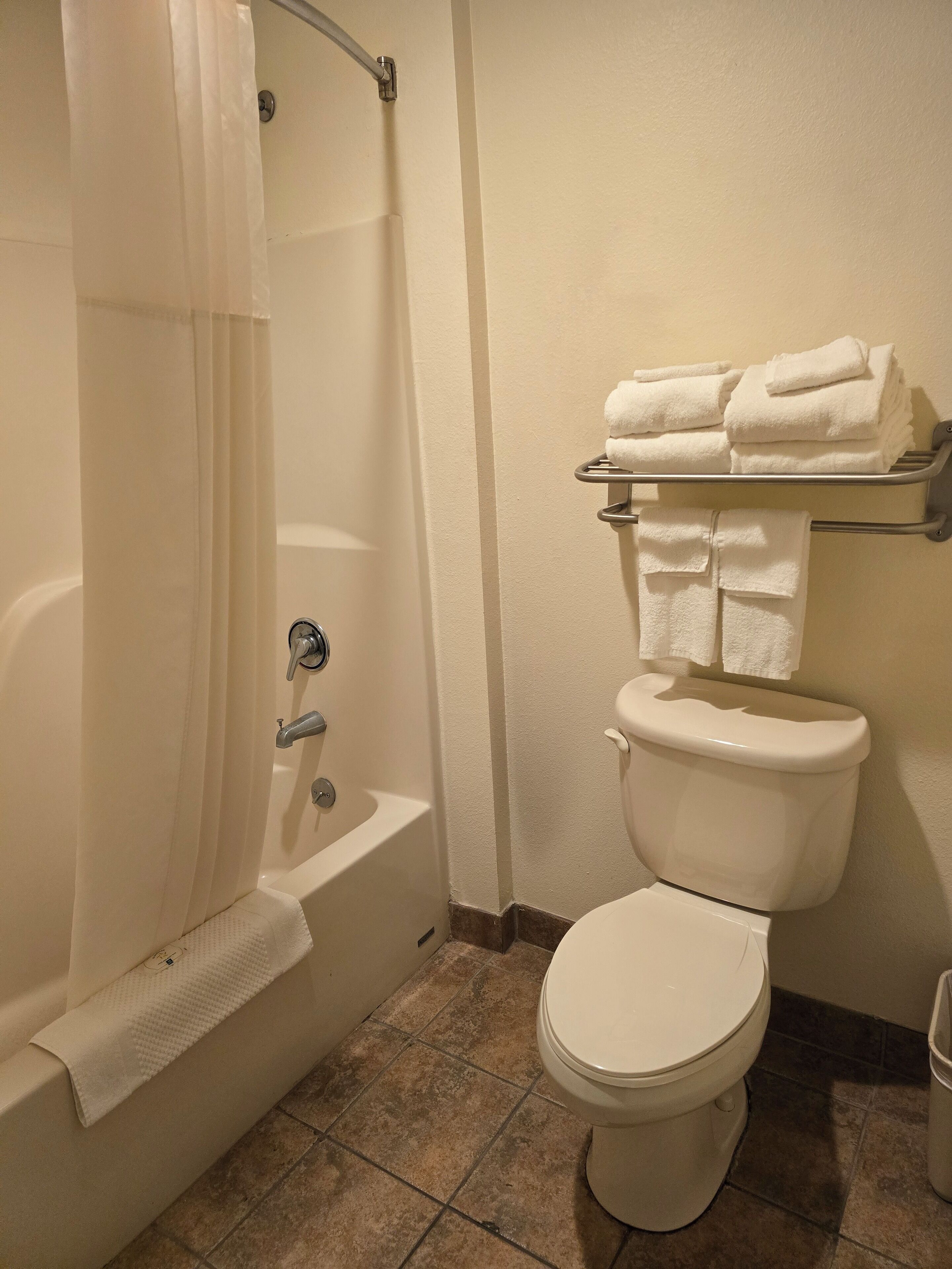 A bathroom with a bathtub, toilet, and towel rack.