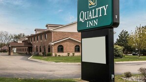Ein Quality Inn Schild vor einem Backsteinhaus.