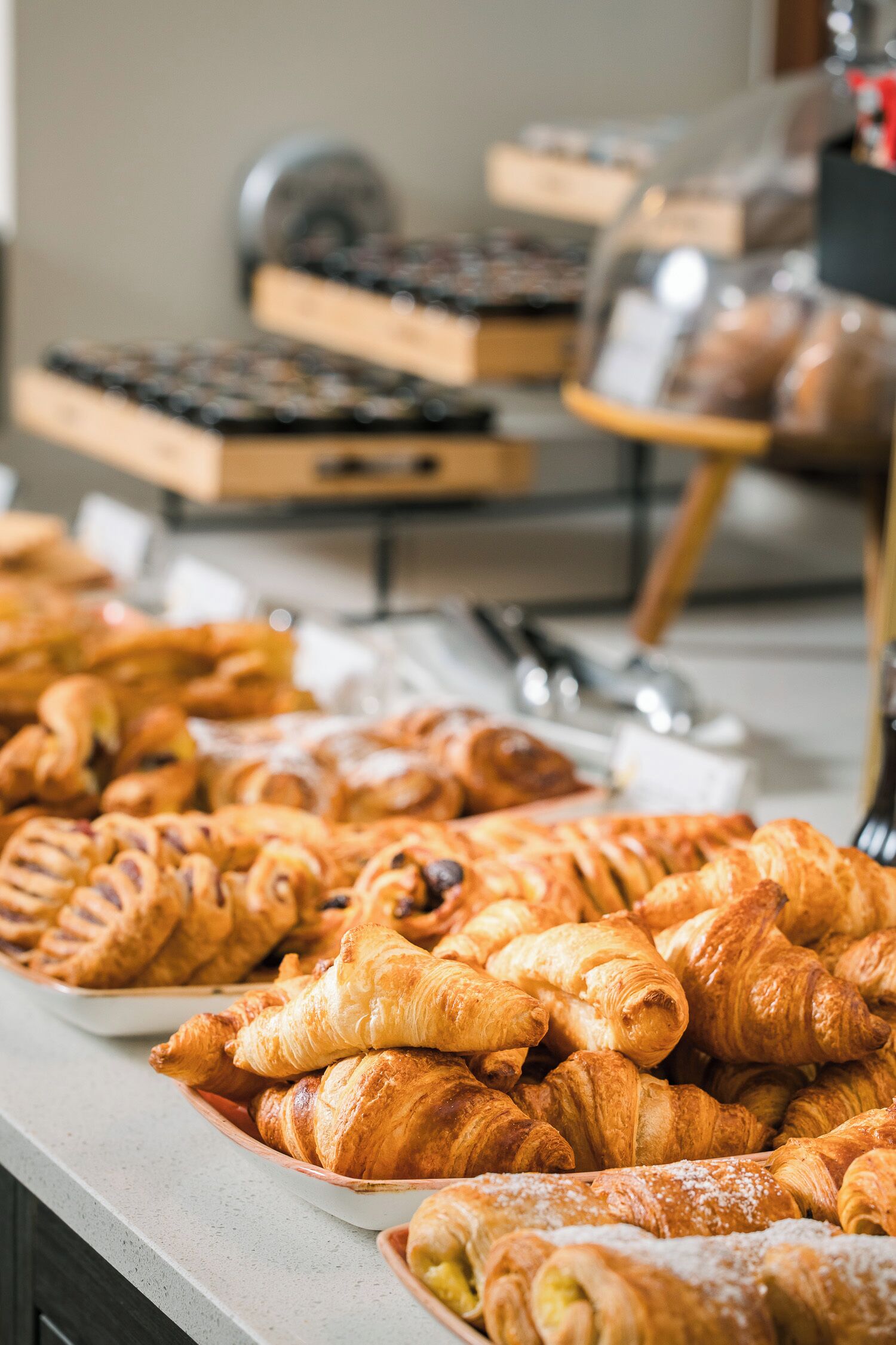 Een verscheidenheid aan gebak, waaronder croissants en ander gebakken lekkers, gepresenteerd op een toonbank.