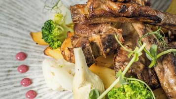 A plate of food with meat, vegetables, and garnishes.