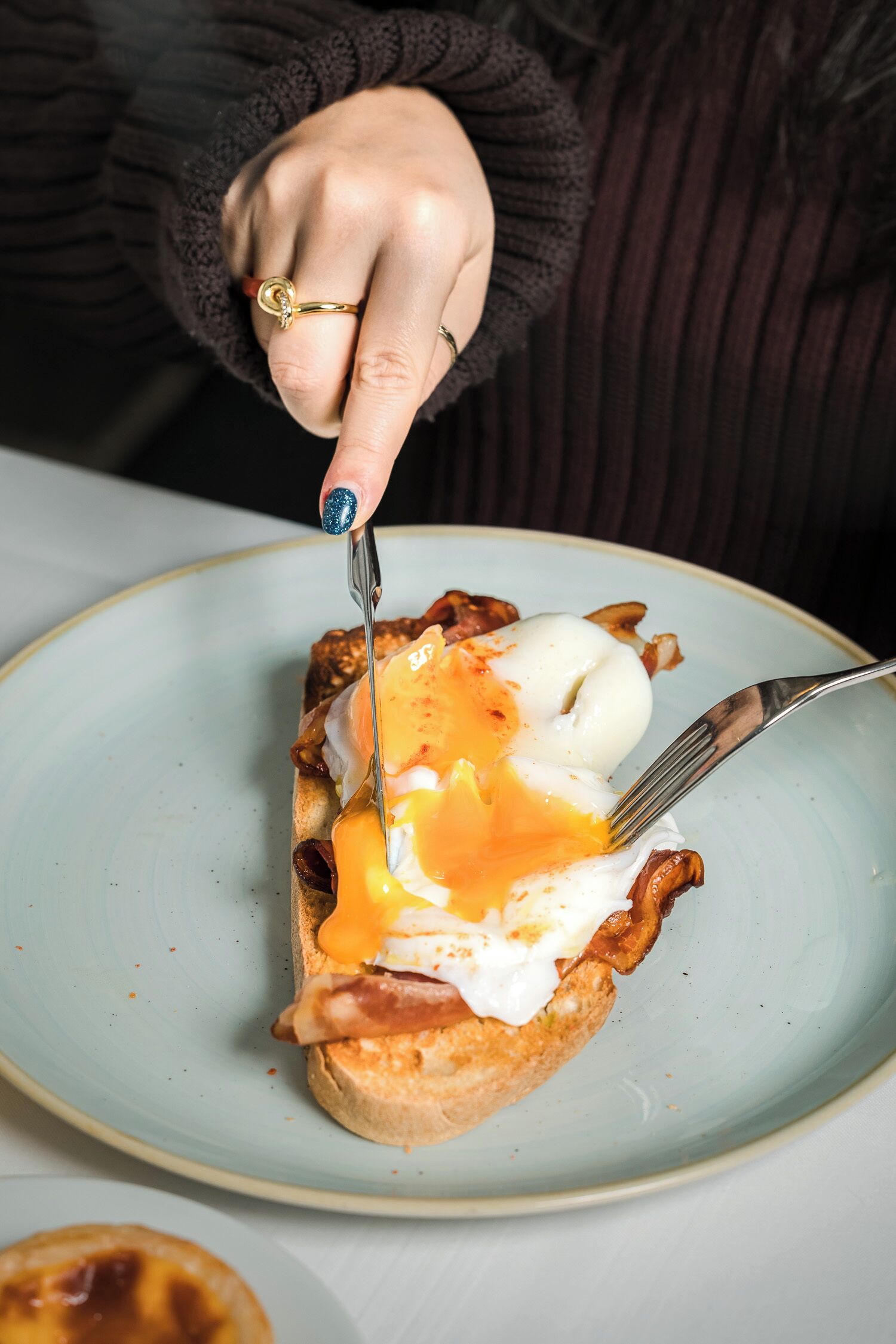 Una persona cortando un plato de desayuno.