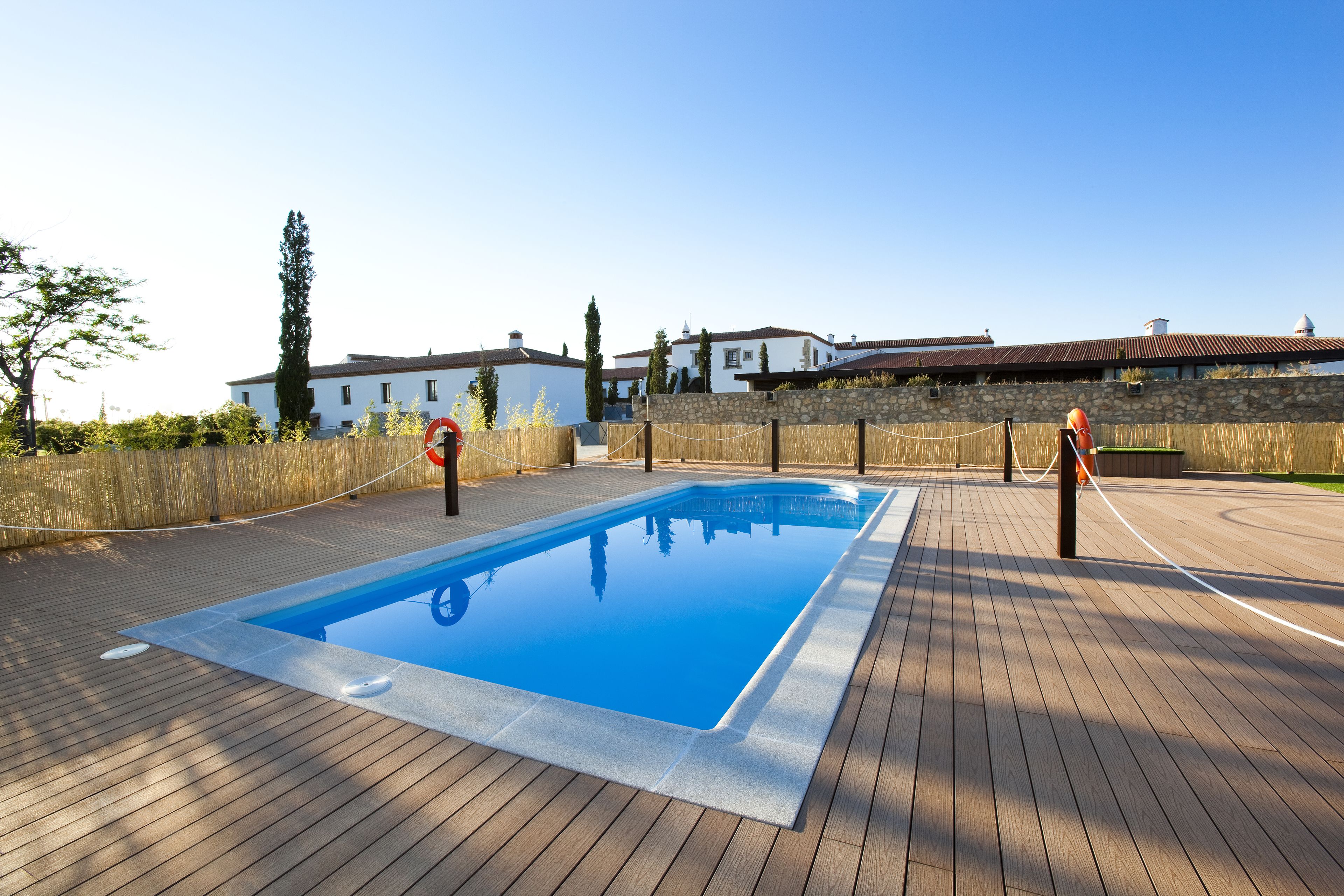 Una piscina rectangular con un borde de madera alrededor.