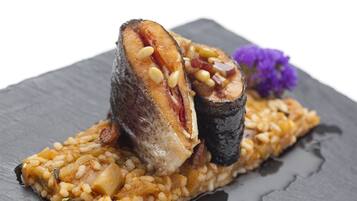 Un plato con una rebanada de carne, frijoles y un adorno sobre una fuente de pizarra.
