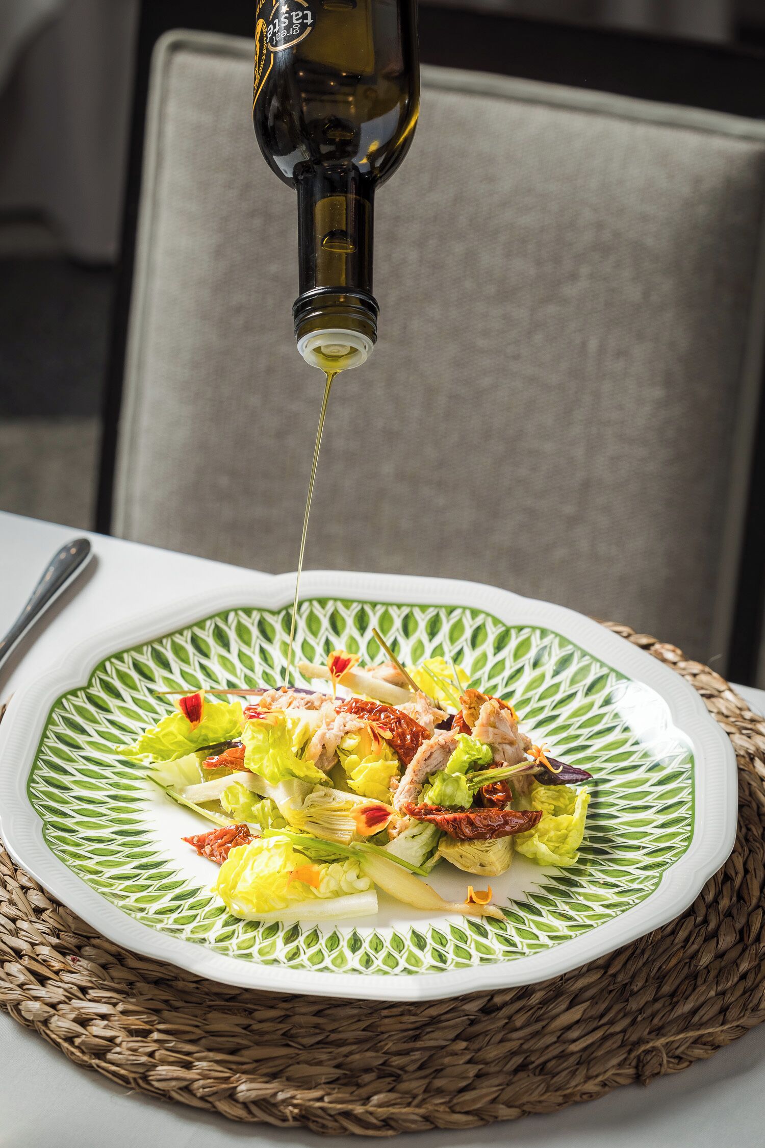 Uma salada com molho sendo adicionado.