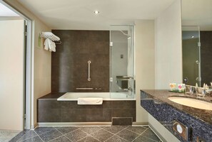 A modern bathroom with a glass-enclosed shower, a freestanding bathtub, and a vanity with a sink and mirror. - Hyatt Place London Heathrow Airport (West Drayton)