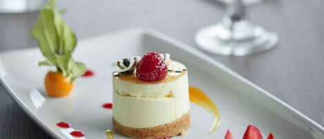 A dessert on a white plate with a glass of white wine in the background.