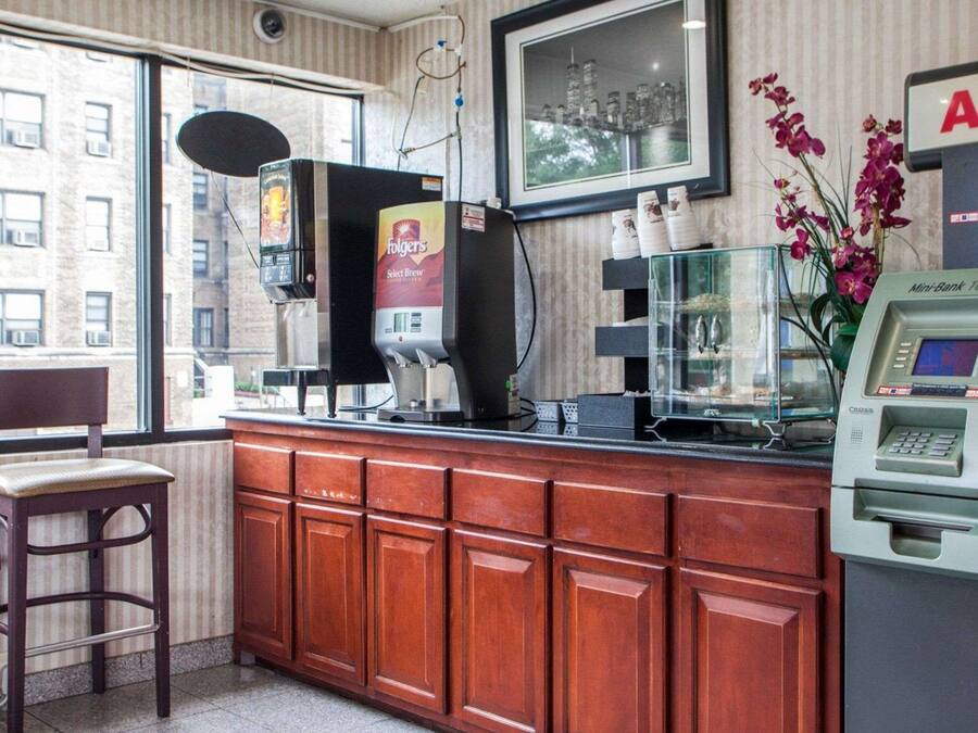 Eine Kaffeestation mit einer Folgers-Kaffeemaschine, einem Mini-Bank-Geldautomaten und einem Aquarium auf der Theke.