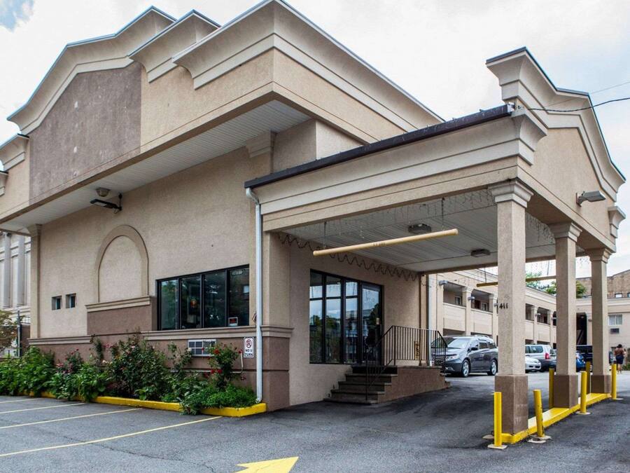 Un bâtiment doté d’une entrée abritée, d’un parking et d’un panneau indiquant qu’il est interdit de faire demi-tour.