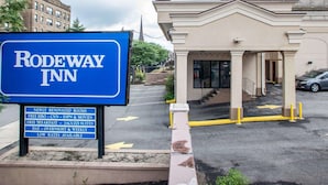 Un letrero de Rodeway Inn con servicios que incluyen habitaciones remodeladas, desayuno gratuito y tarifas bajas.