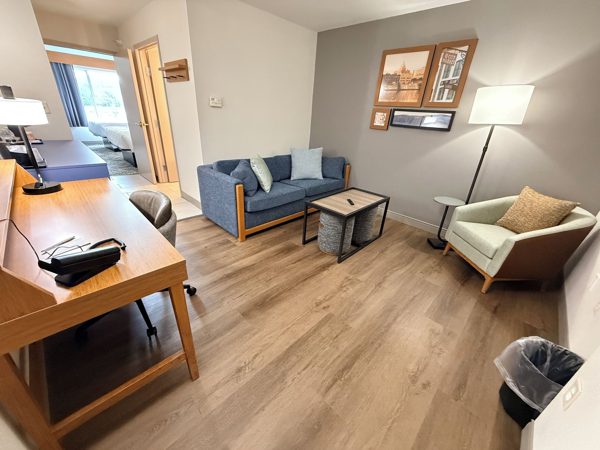 Ein modernes Wohnzimmer mit einer Couch, einem Couchtisch, einem Schreibtisch mit Lampe und einem Sessel.