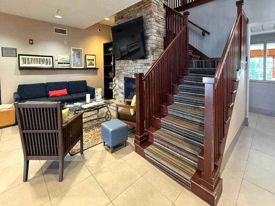 A living room with a fireplace, a staircase, and a sofa.