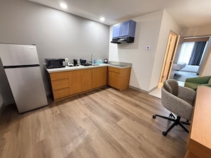 A compact kitchen with a refrigerator, microwave, sink, and wooden cabinets. - Country Inn & Suites by Radisson, Lima (Lima)