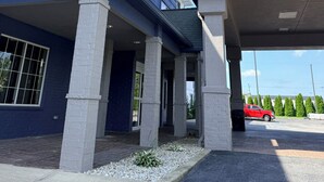 A hotel with a modern design, featuring a prominent blue facade and a covered entrance area. - Country Inn & Suites by Radisson, Lima (Lima)