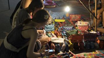 Un puesto de mercado con varias bolsas y textiles.