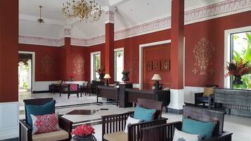 A spacious lobby with red walls, wooden furniture, and decorative elements.