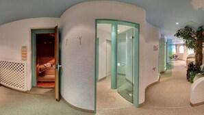 Un espace détente avec un jacuzzi, un escalier et une porte vitrée donnant sur une autre pièce.