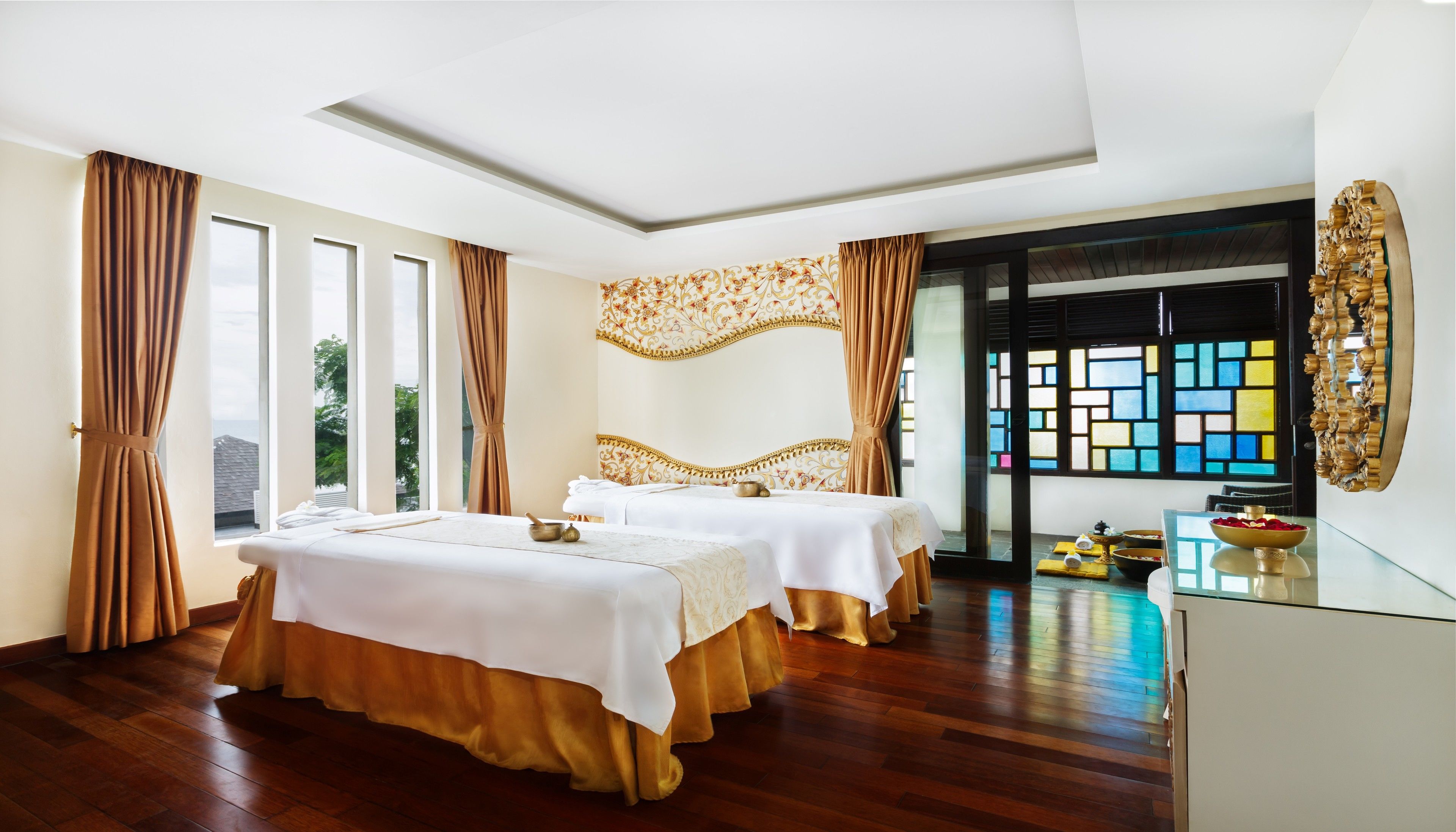 Habitación de hotel con dos camas, un ventanal grande y un panel decorativo en la pared.