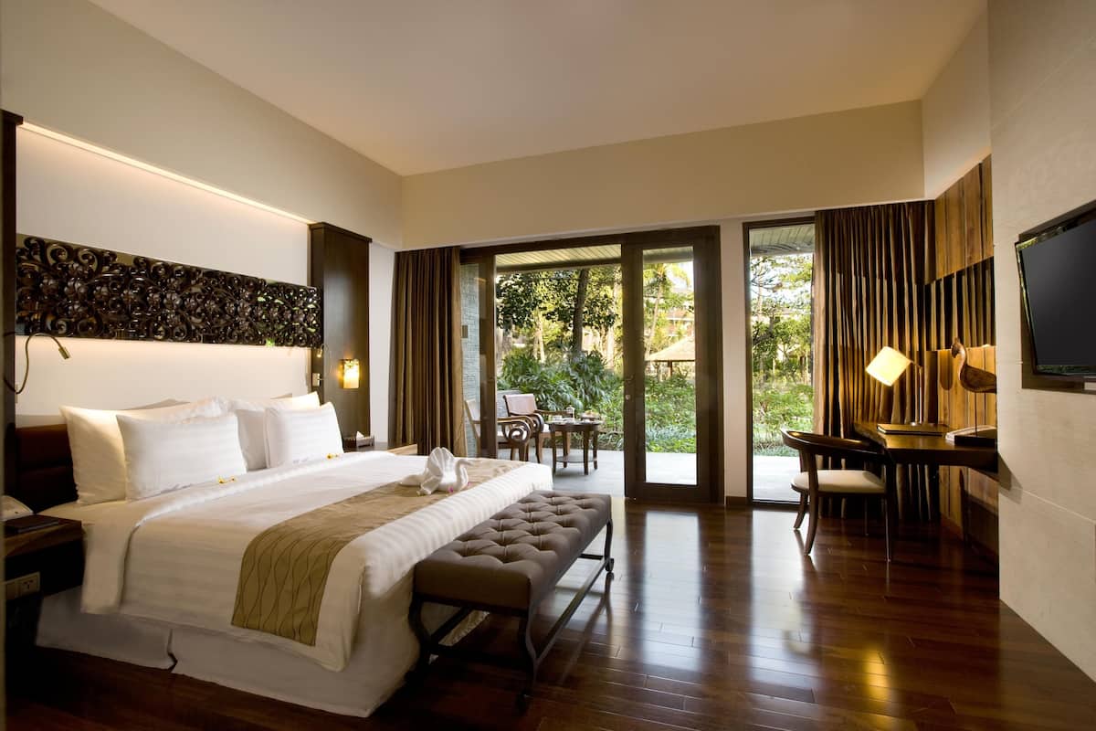 A spacious hotel room with a large bed, a desk, and a television.