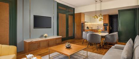 A modern living room with a sofa, a coffee table, and a dining area with chairs.