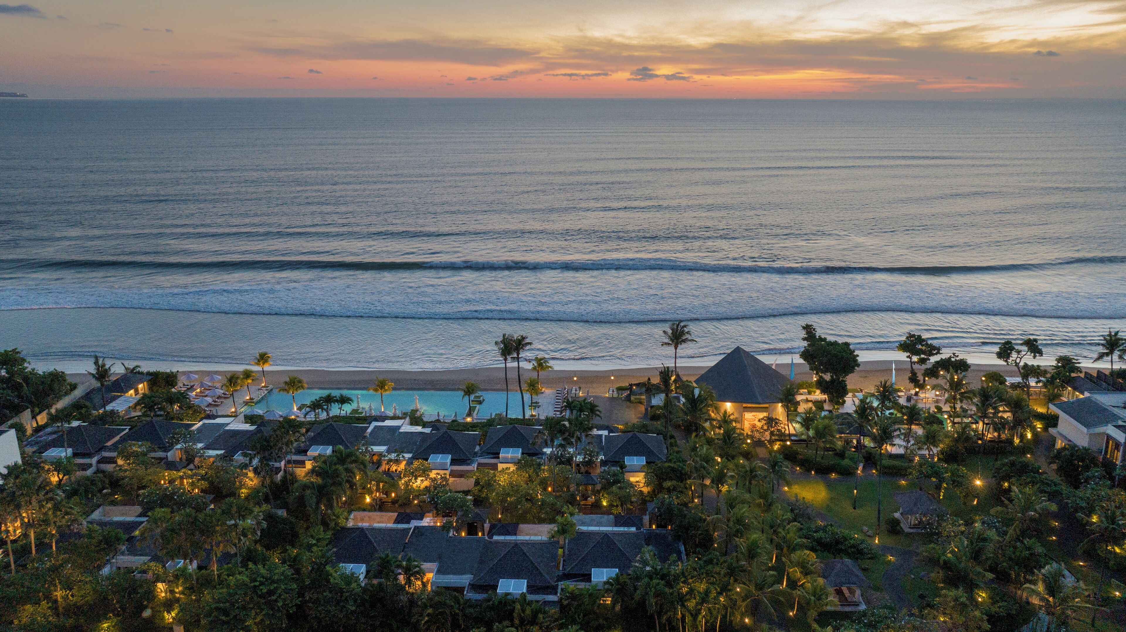 A resort with a pool, beach, and ocean view.