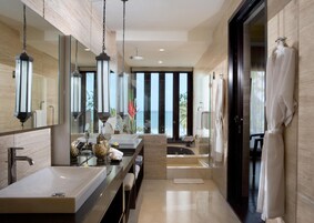 Uma casa de banho moderna com duas pias, um espelho grande e vista para o oceano.
