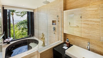 A modern bathroom with a glass-enclosed shower, a bathtub, and a large mirror.