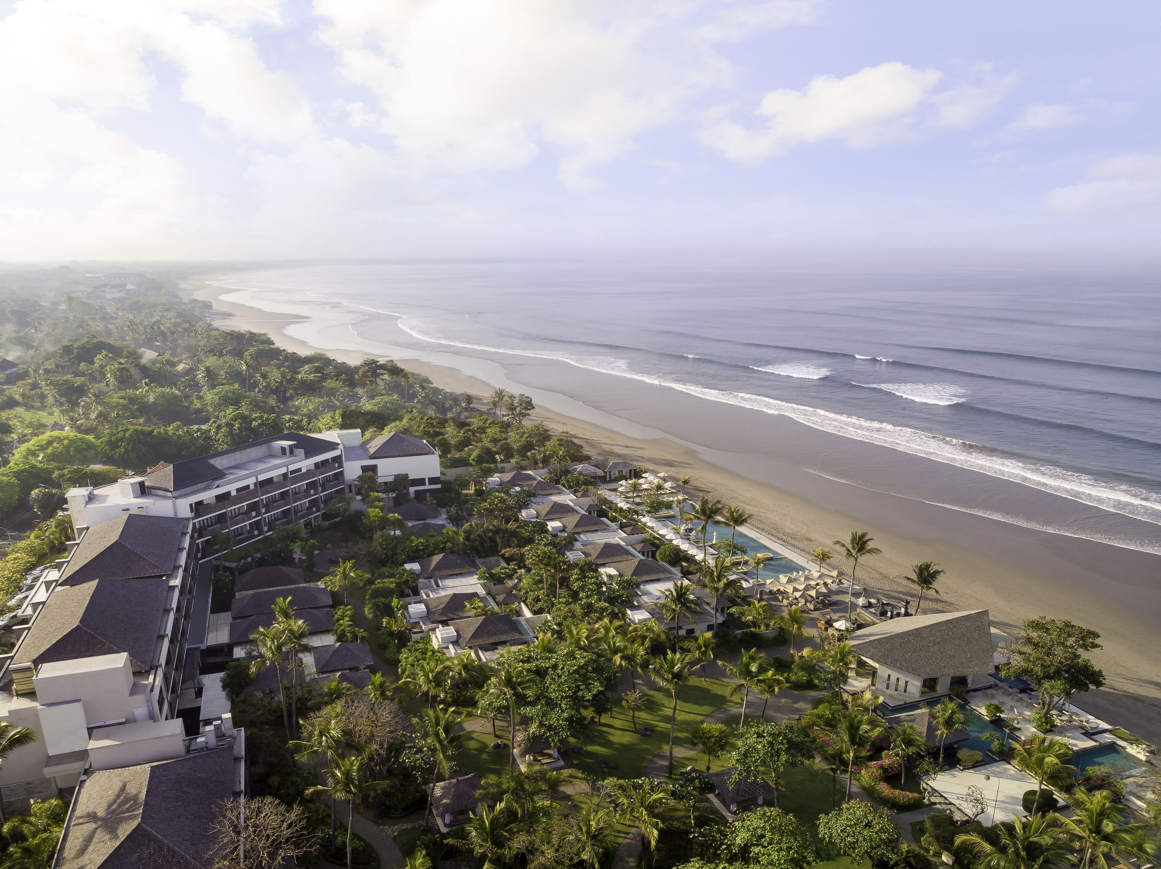 Ein Resort mit mehreren Gebäuden, einem Strand und einem Poolbereich.