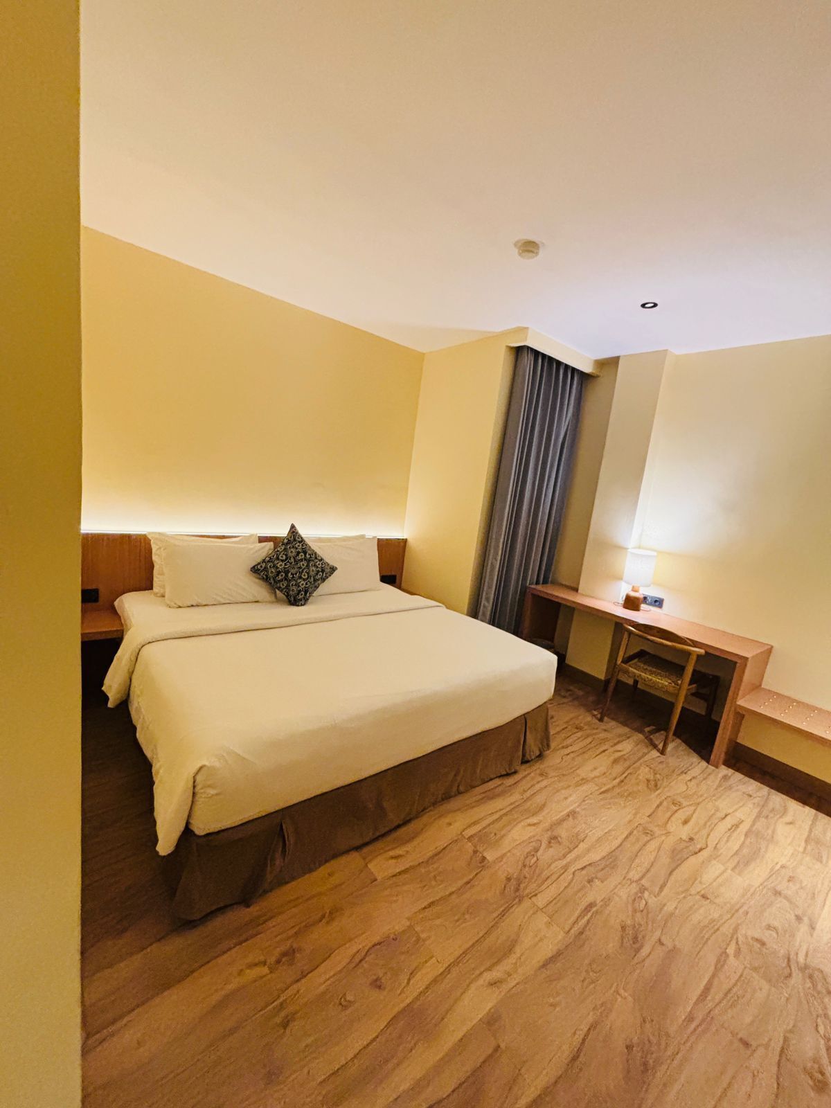 Una habitación de hotel con una cama, un escritorio y una silla.