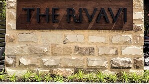 A stone wall with a sign that reads "THE RIVAVI". - The Rivavi Legian (Legian)