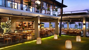 A modern hotel with a bar, dining area, and outdoor seating. - Bali Niksoma Boutique Beach Resort (Legian)