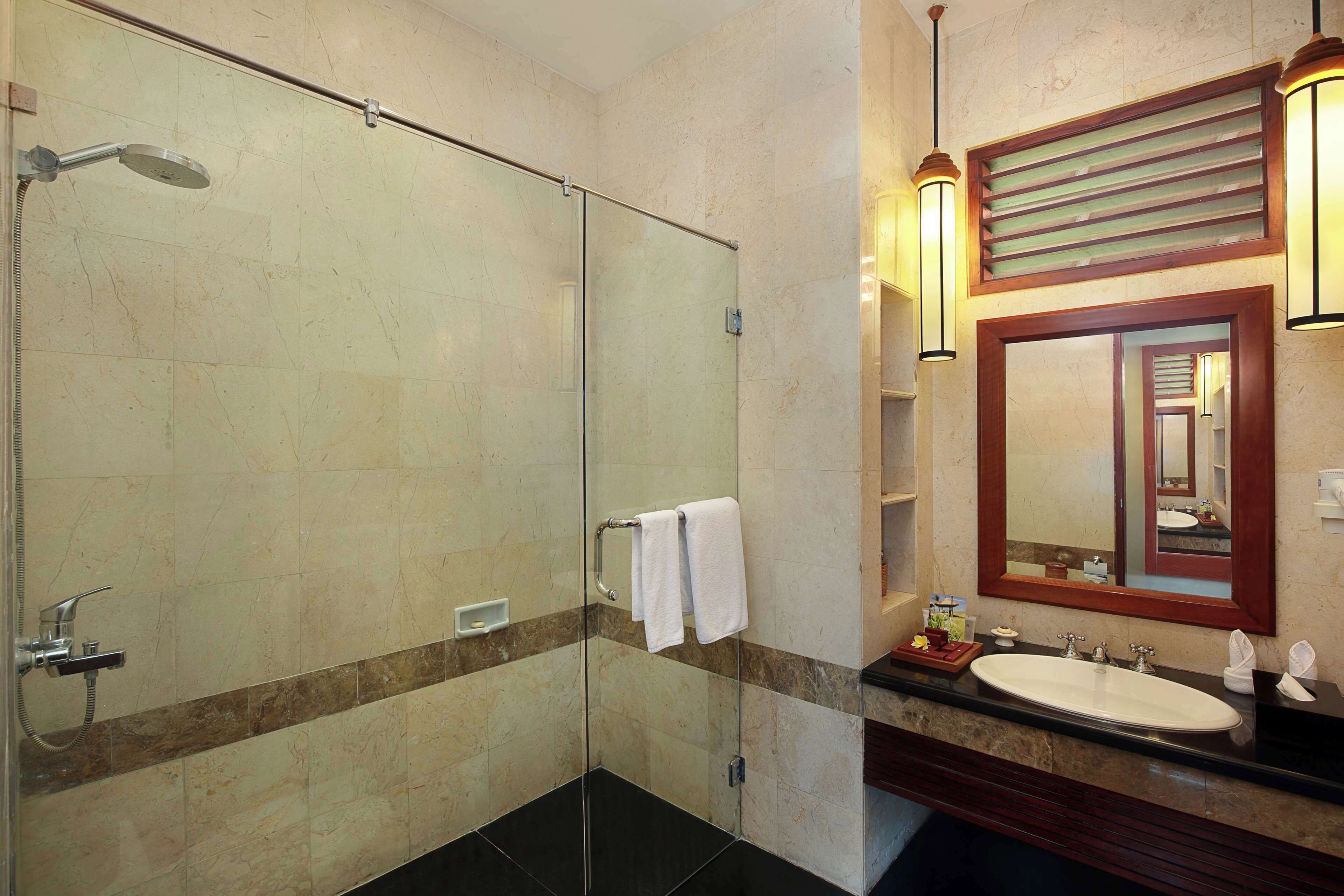 Une salle de bain moderne avec une douche à parois de verre, un meuble-lavabo et un grand miroir.