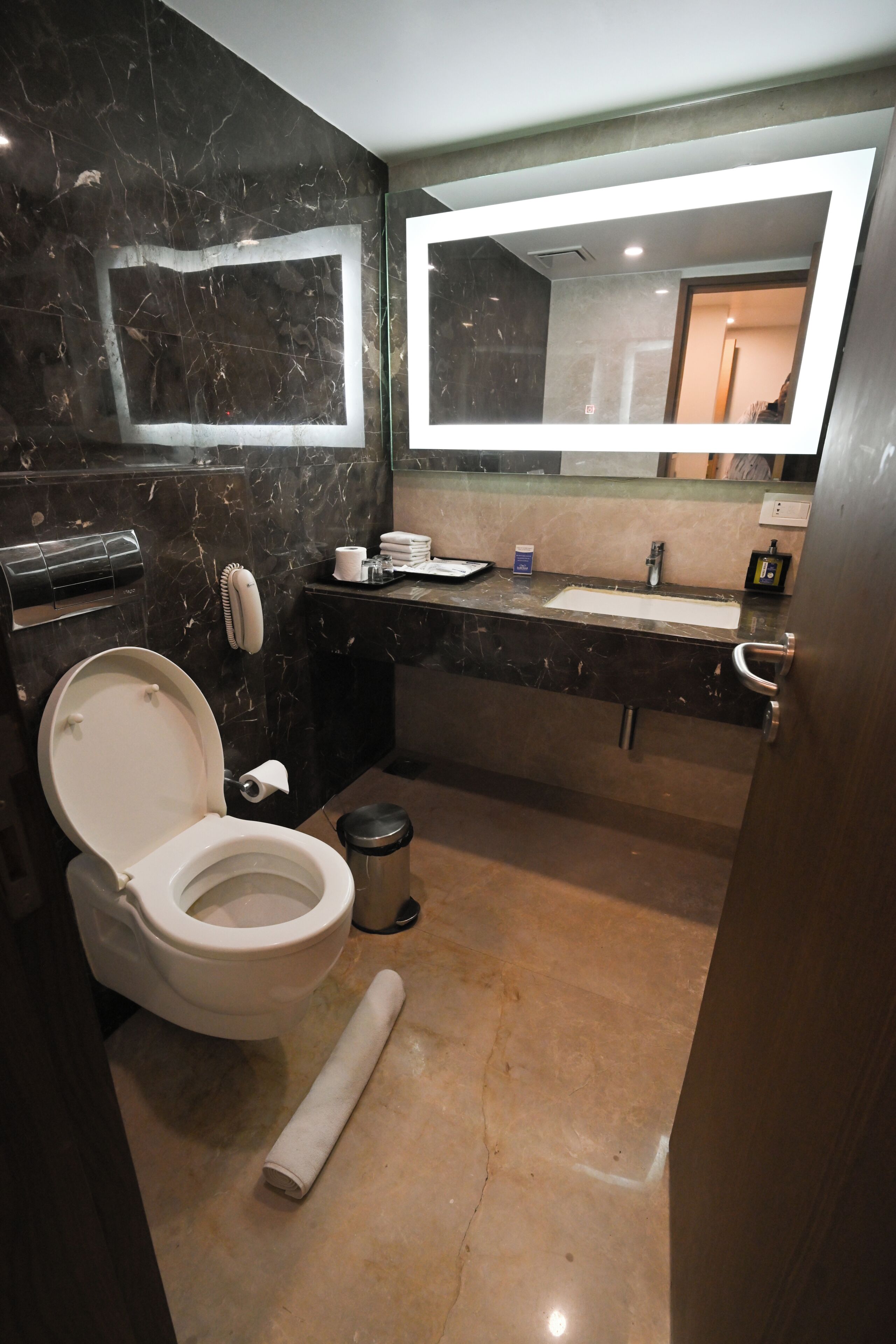 A modern bathroom with a toilet, sink, and mirror.