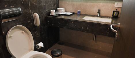 A modern bathroom with a toilet, sink, and mirror.