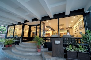 A hotel entrance with a staircase, a bell desk, and potted plants. - Rivera Sarovar Portico Ahmedabad (Ahmedabad)