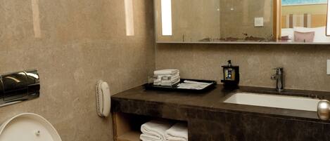 A modern bathroom with a toilet, sink, and mirror.